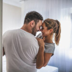 Loving young couple relaxing at home and kissing
