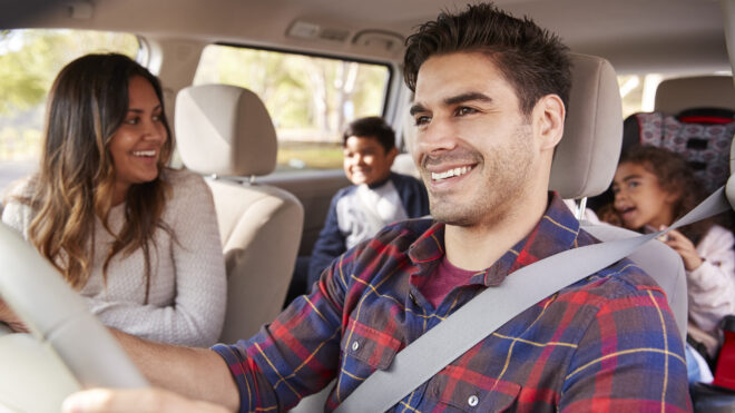 Latina mom turns around to her children on the back seat of car
