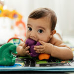Baby playing with toys on the floor.