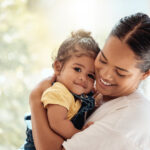 Family, love and care with a hug, love and support of mother for baby while together at home for quality time, bonding and happiness. Woman carrying child for security and safety in their family home