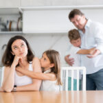Domestic quarrel in big family – daughter hugging upset mom, son hugging sad father