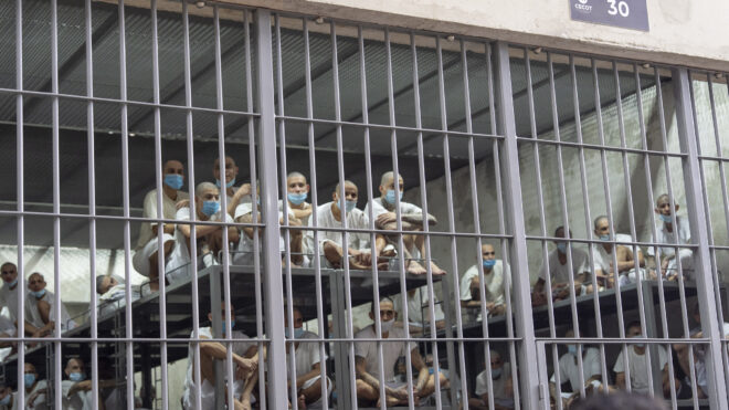 Prisoners look out of their cell at the Terrorist Confinement Center