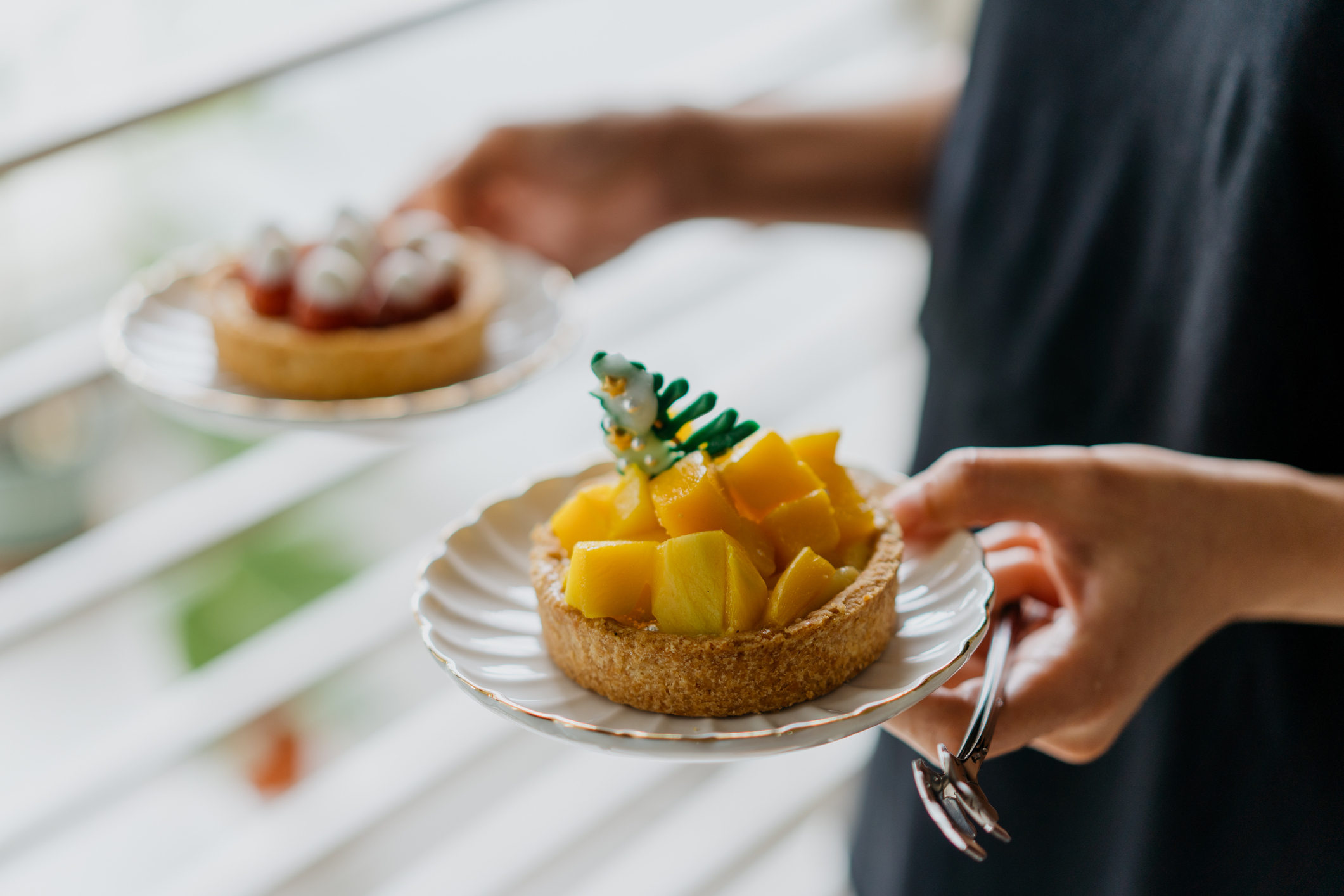 Woman holding fruit tarts dessert at home