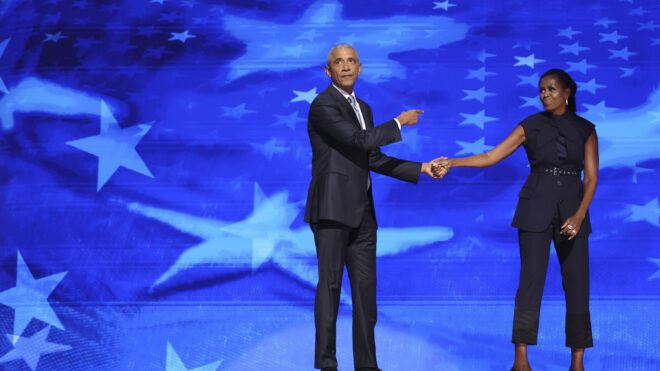 Former President Barack Obama and former first lady Michelle Obama embrace on stage