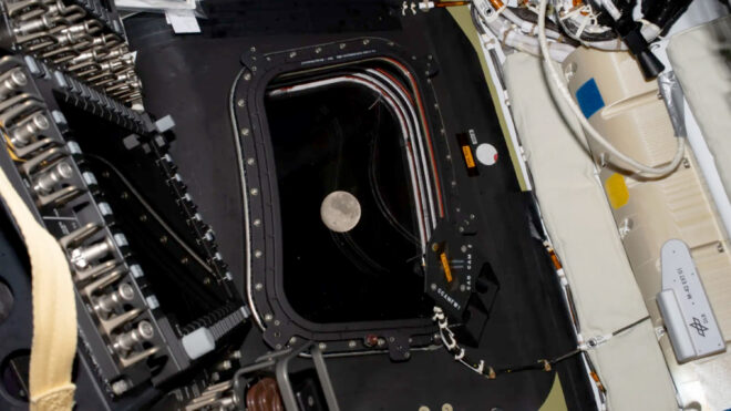 The moon can be seen out a window of the Orion spacecraft as the Artemis II crew make their approach