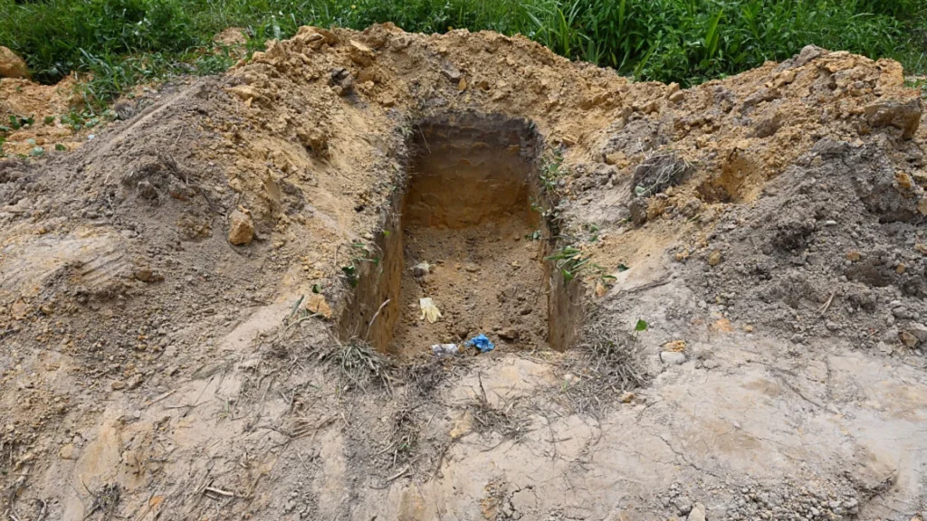 A view of an open grave at the cemetery of Cumuto, Trinidad and Tobago, taken on April 18, 2026. The remains of at least 50 infants and six adults were discovered on April 18, 2026, after they had apparently been discarded at a cemetery in Trinidad and Tobago, police said.